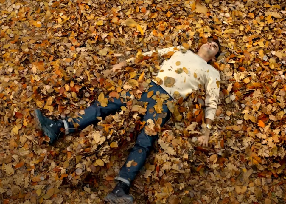 He is seen at the end of the video playing in the leaves