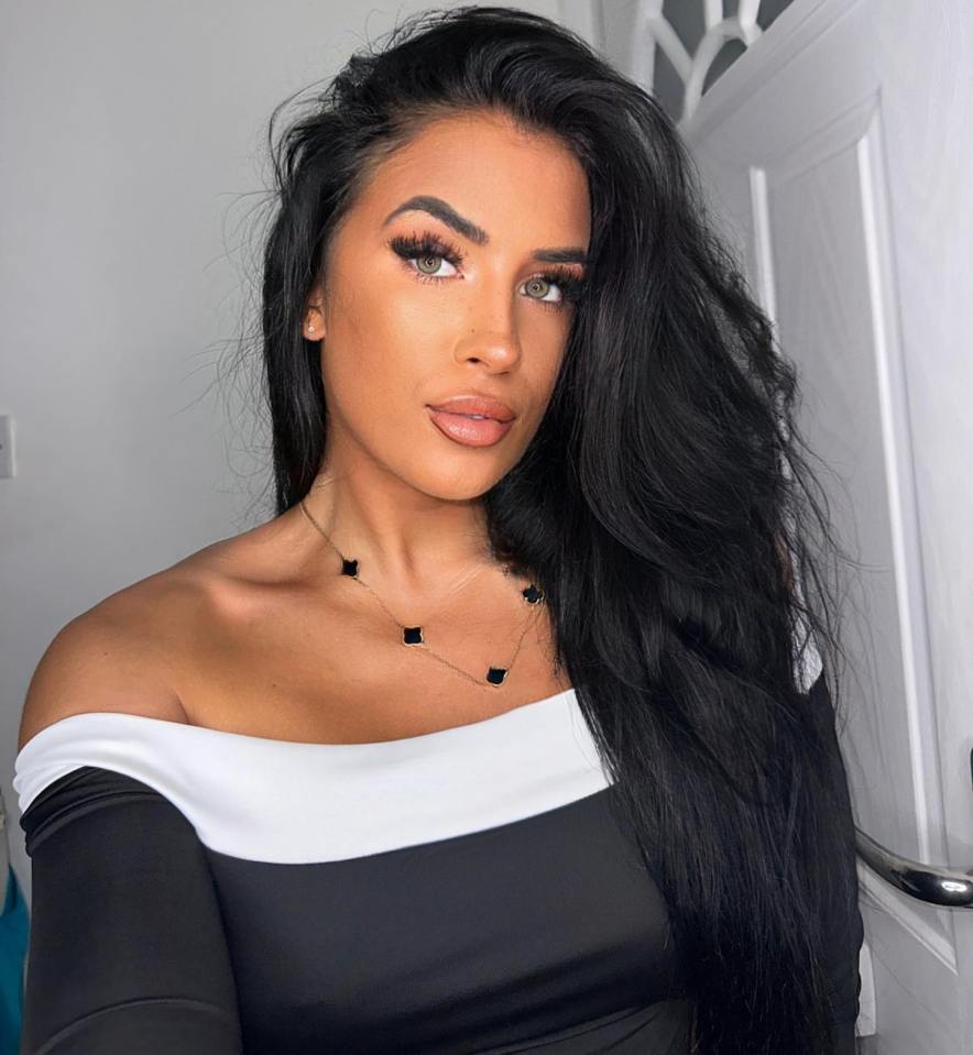 a woman with long black hair is wearing a black and white off the shoulder top