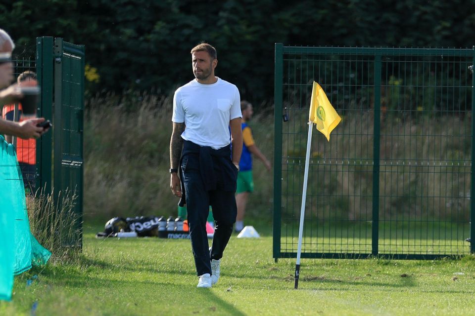 a man in a white shirt stands in front of a yellow flag