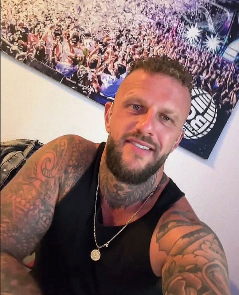 a man with a beard and tattoos is taking a selfie in front of a poster that says music