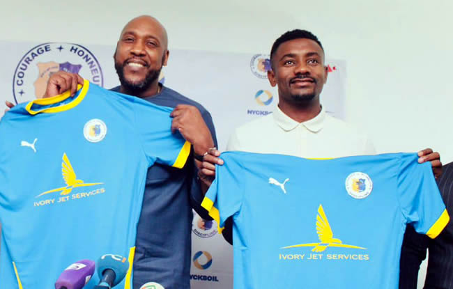 two men holding up ivory jet services jerseys