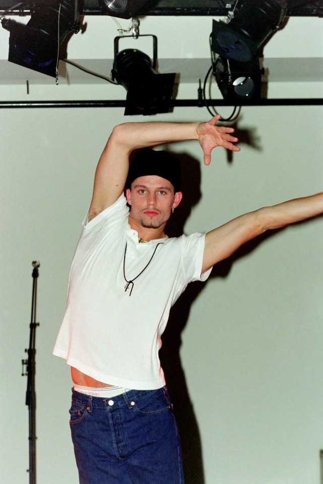 a man with his arms outstretched wearing a white calvin klein shirt