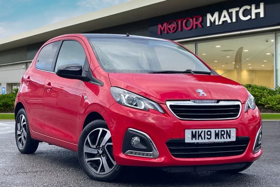 a red car is parked in front of a motor match store