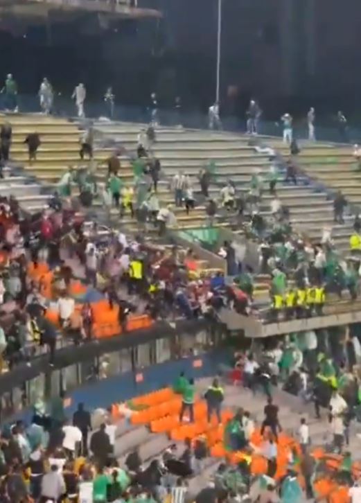 a crowd of people are standing in a stadium .