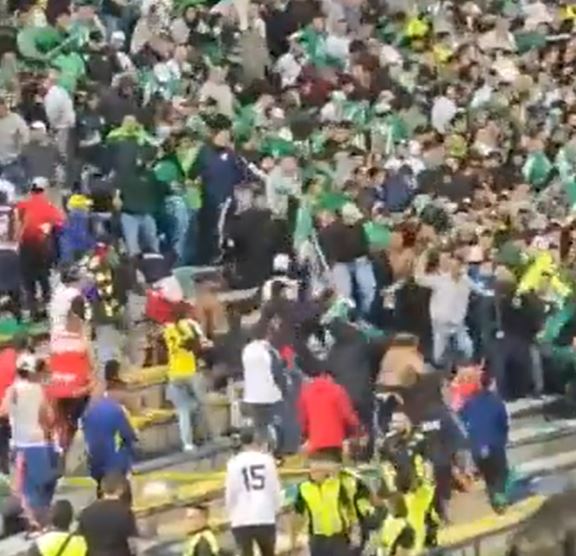 a crowd of people are standing in a stadium watching a game .