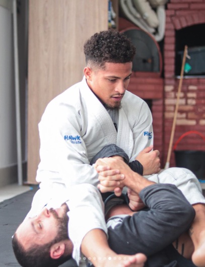 a man in a hawk martial arts uniform holds another man