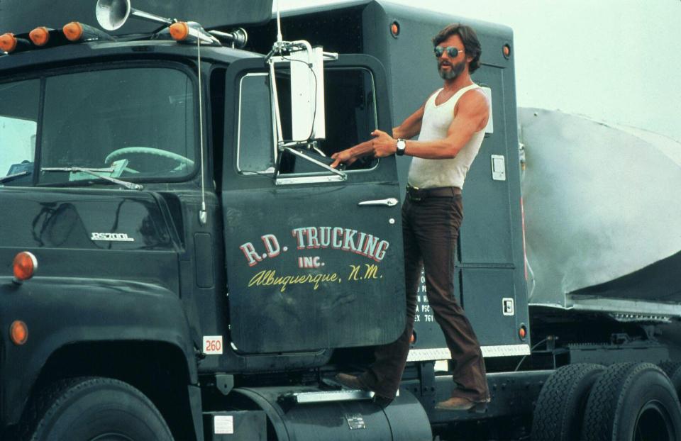 a man stands on the side of a truck that says r.d. trucking inc.