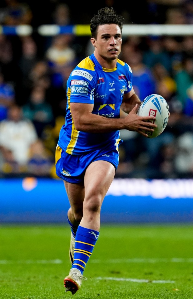 a rugby player in a blue and yellow uniform runs with the ball