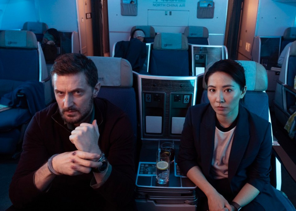 a man and a woman sit on an airplane with a sign that says north china air