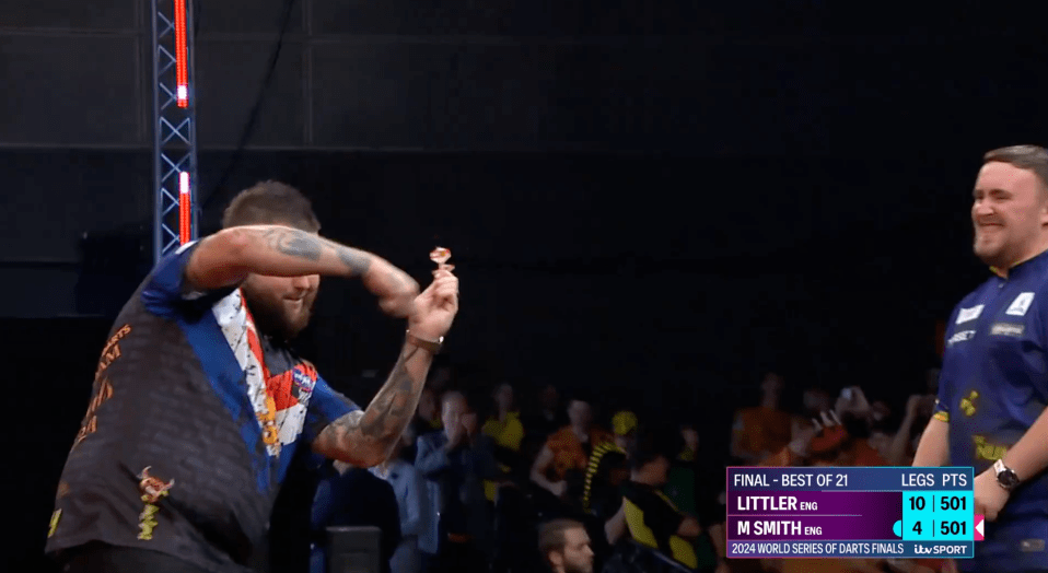 a man holding a dart in front of a scoreboard that says final best of 21