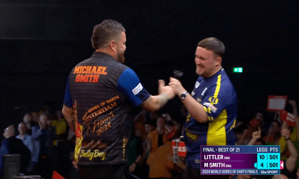 a man wearing a michael smith shirt shakes hands with another man