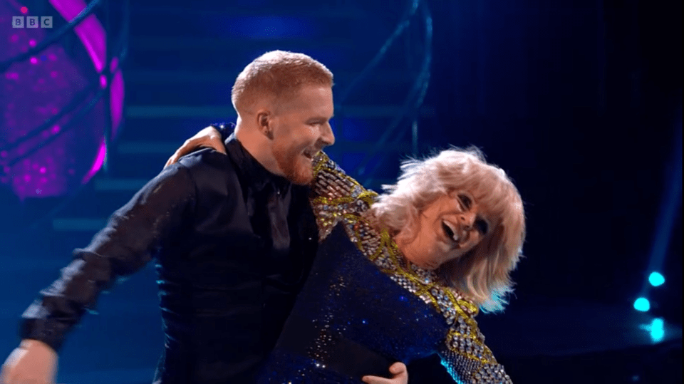 a man and a woman are dancing in front of a bbc logo