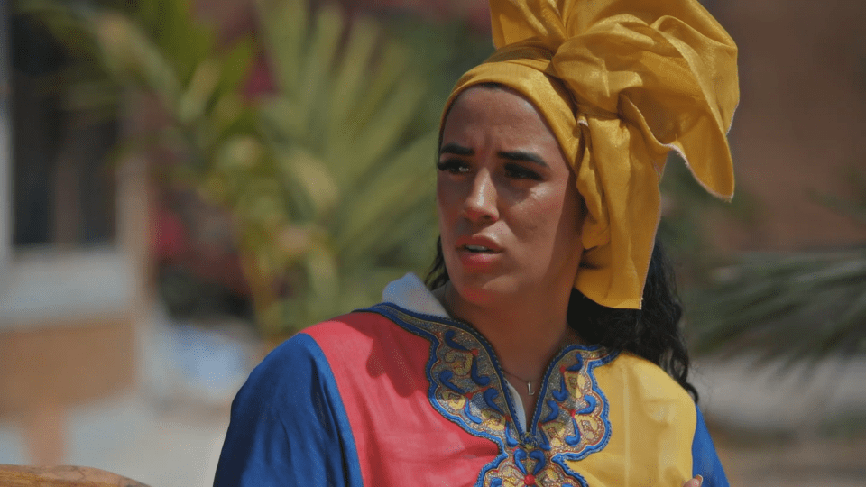 a woman wearing a yellow head scarf and a blue shirt