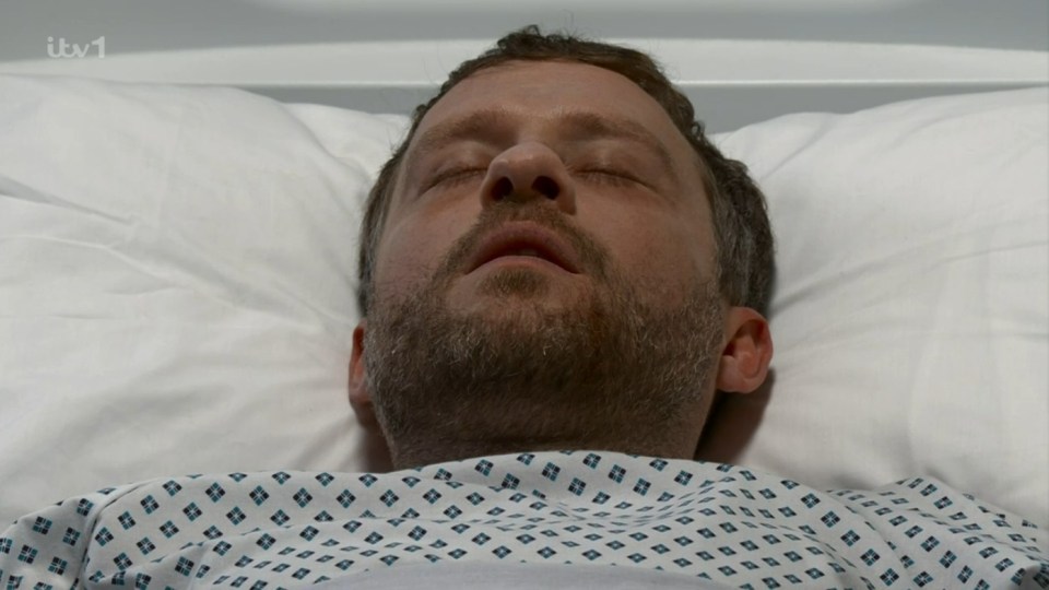 a man is laying in a hospital bed with his eyes closed