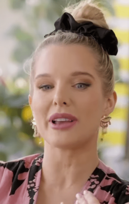 a close up of a woman 's face with a bun and earrings