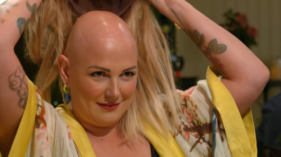 a woman with a shaved head is wearing a yellow robe