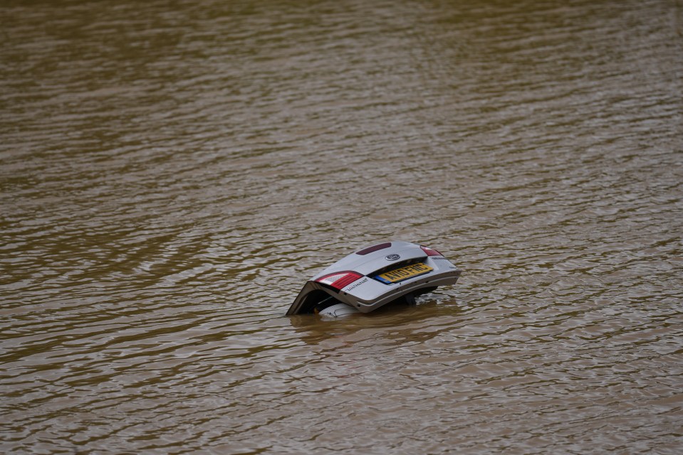 A vehicle is totally submerged in flood water on the A421 in Marston Moretaine, Bedfordshire this morning