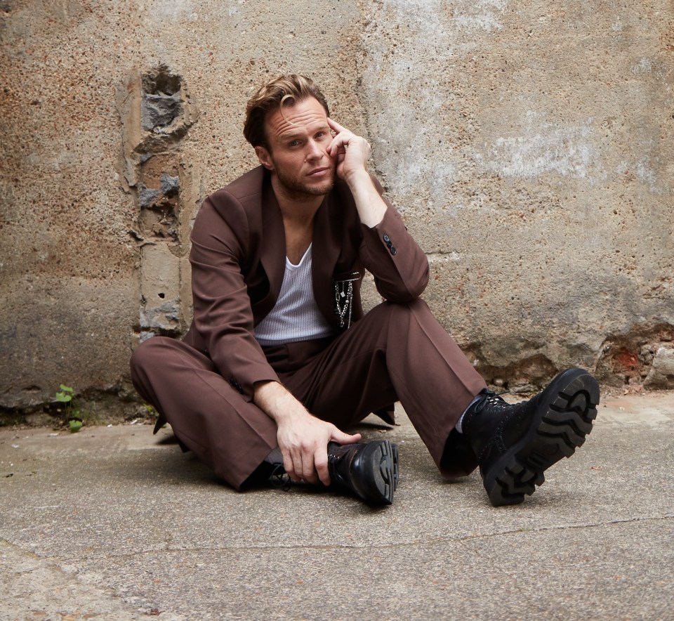 a man sitting on the ground talking on a cell phone