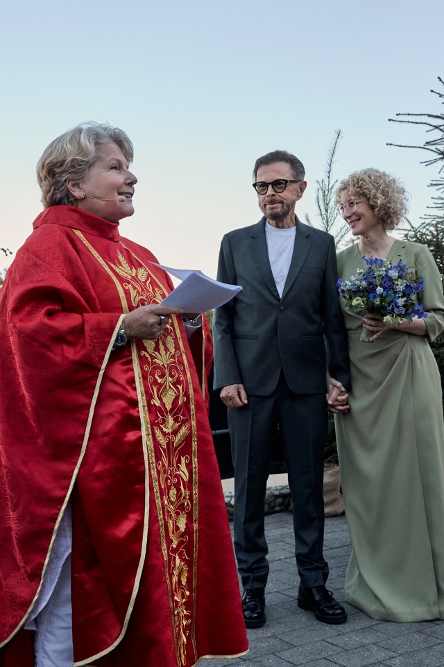 a woman in a red robe is standing next to a man and woman