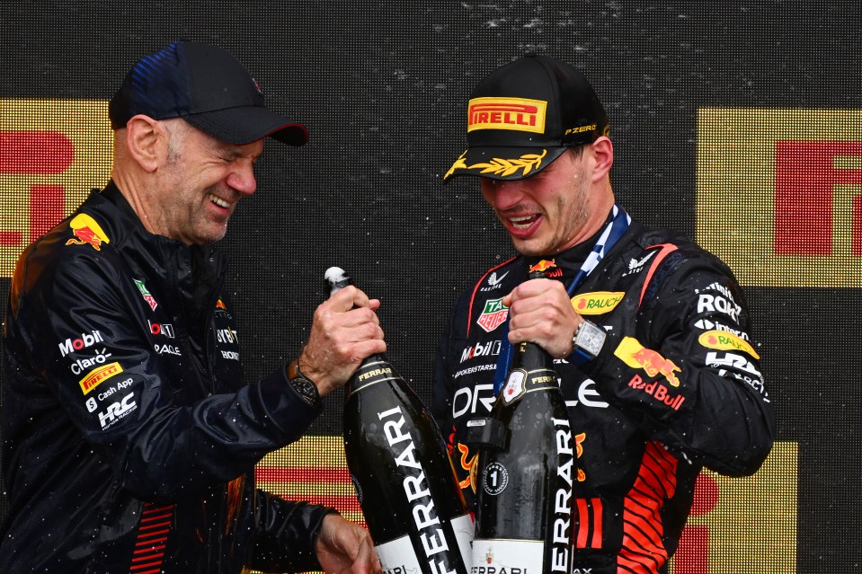 a man holding a bottle of ferrari champagne next to another man