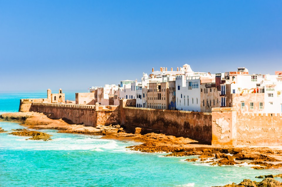 a row of white buildings on a cliff overlooking the ocean