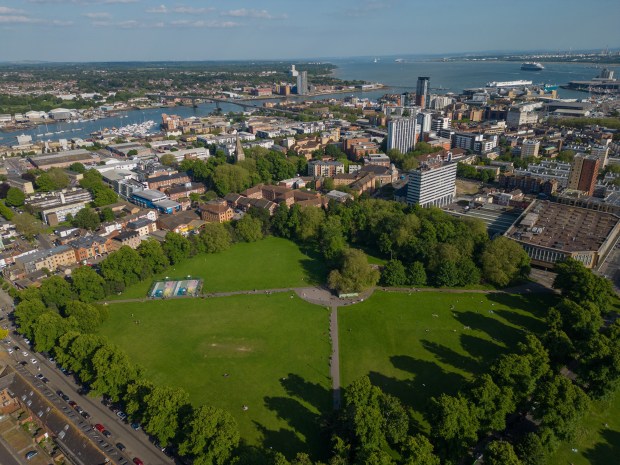 an aerial view of a city with a park in the foreground