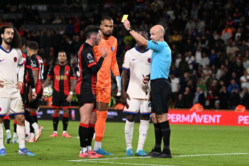 a referee gives a yellow card to a soccer player