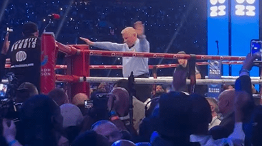 a referee in a boxing ring with the number 23 behind him