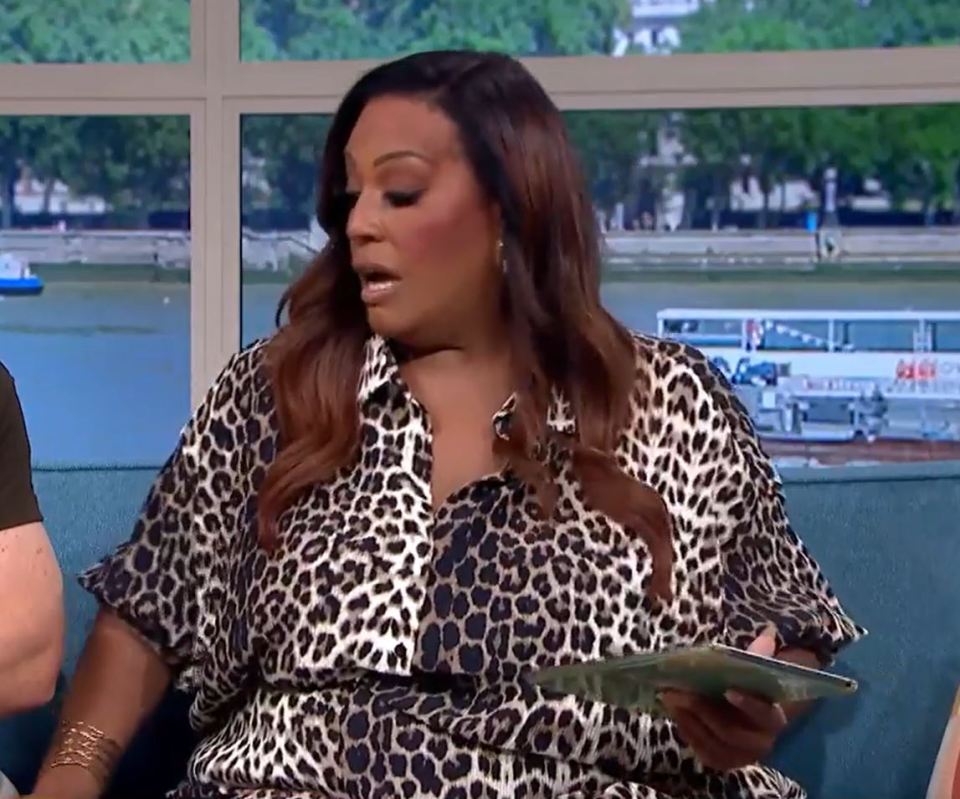 a woman in a leopard print shirt is sitting on a couch