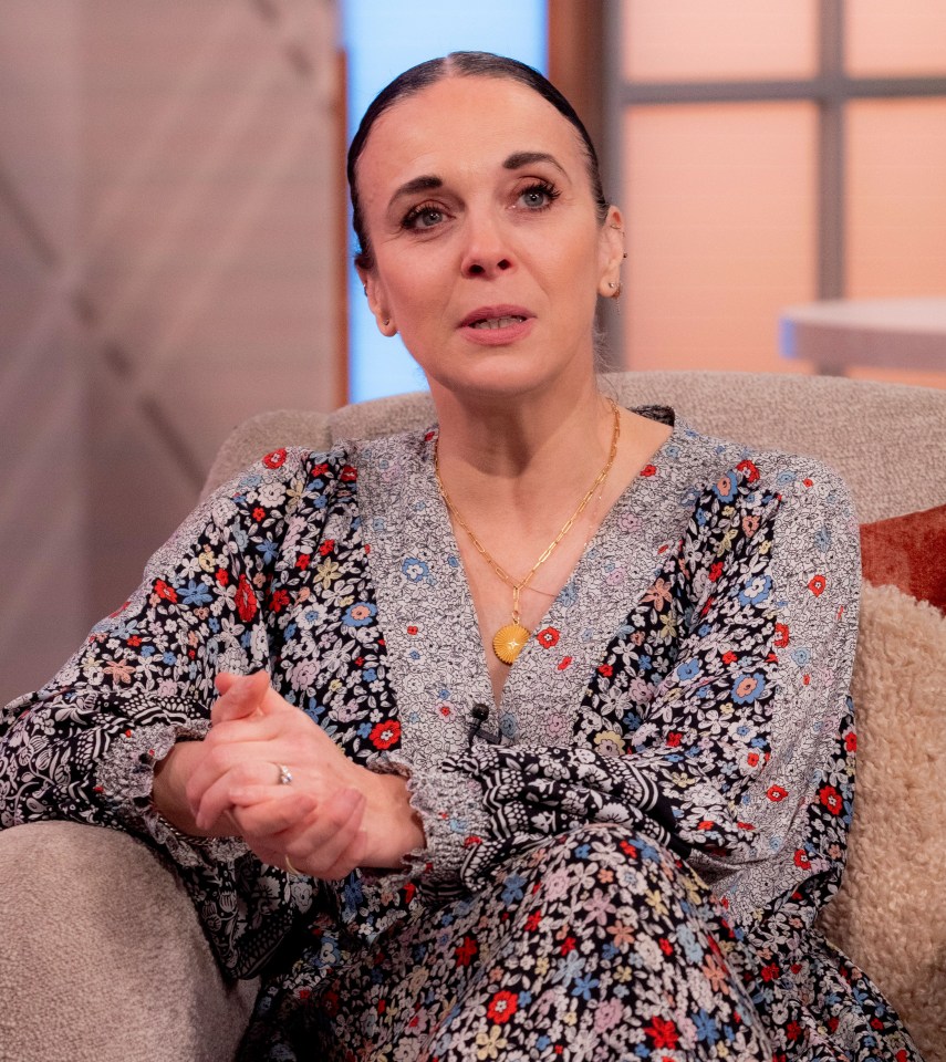 a woman in a floral dress sits in a chair with her hands folded