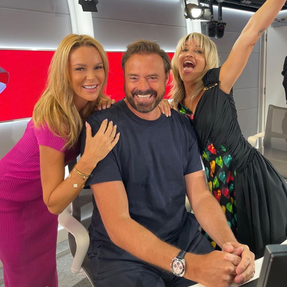 three people posing for a picture with one wearing a watch