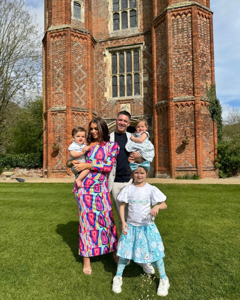 a family posing for a picture in front of a brick building