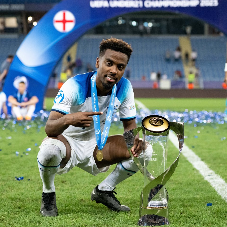 a soccer player kneeling on the field holding a trophy