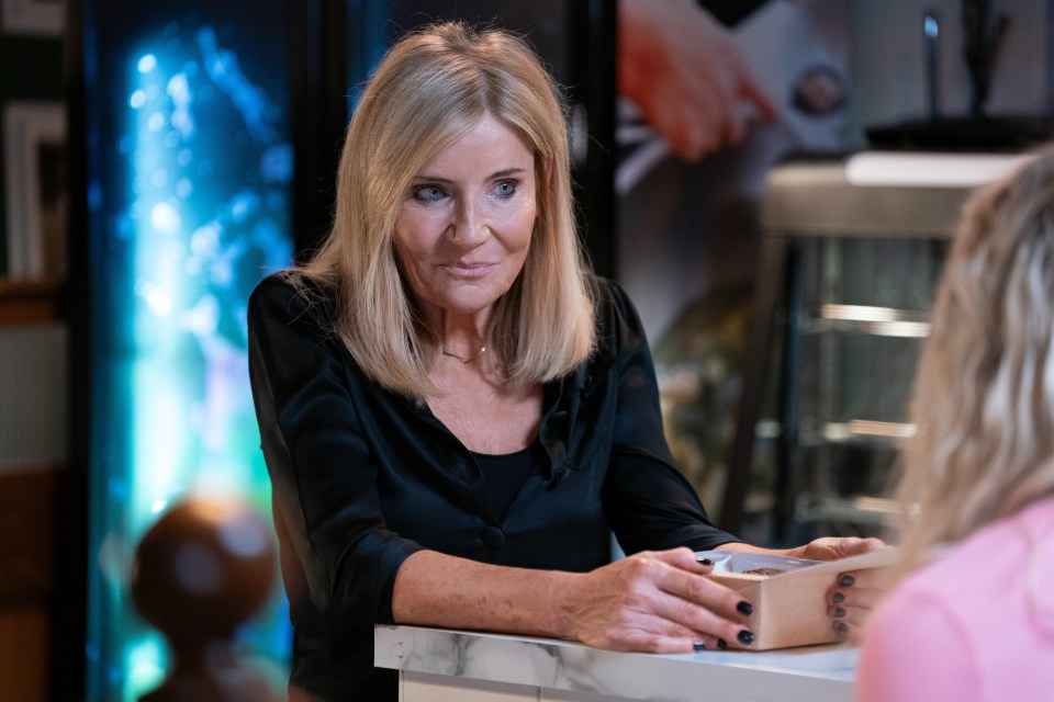 a woman sitting at a counter talking to another woman