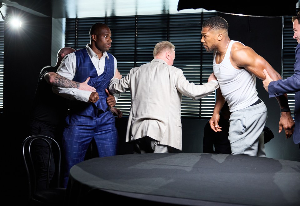 a man in a white tank top stands between two men in suits