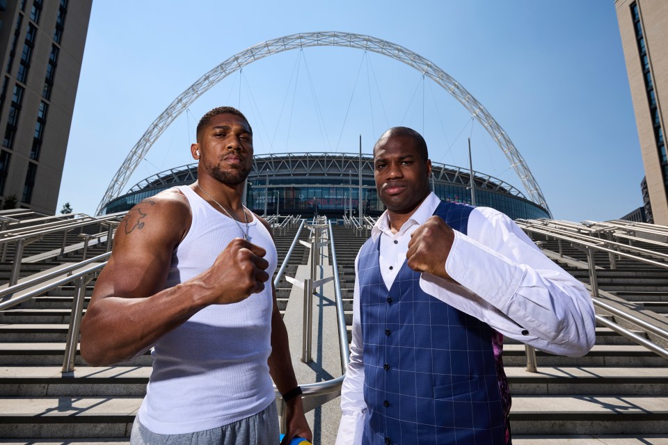 two men standing next to each other in front of a stadium