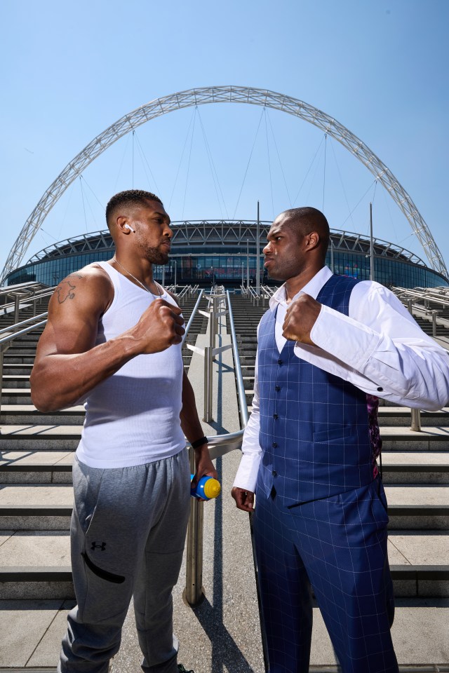 two men standing next to each other in front of a stadium