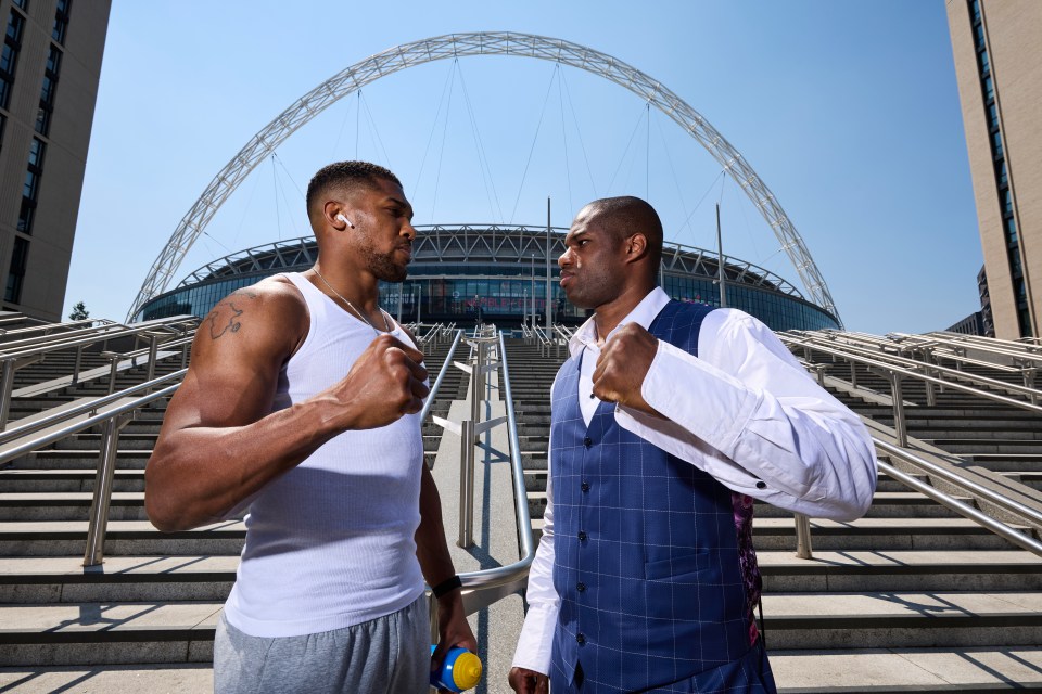 two men standing next to each other in front of a stadium