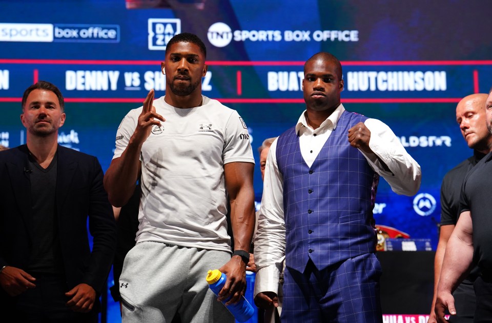 two men standing in front of a sports box office sign