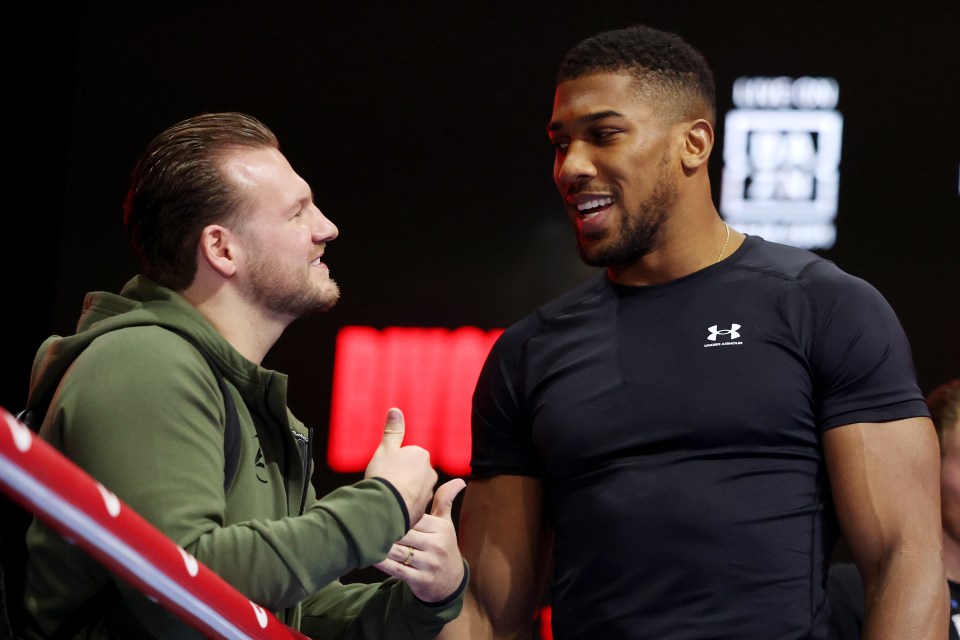 a man wearing an under armour shirt talks to another man