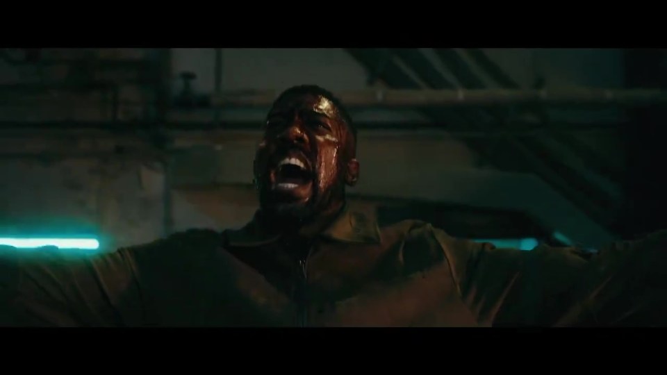 a man is screaming with his mouth open in a dark room .