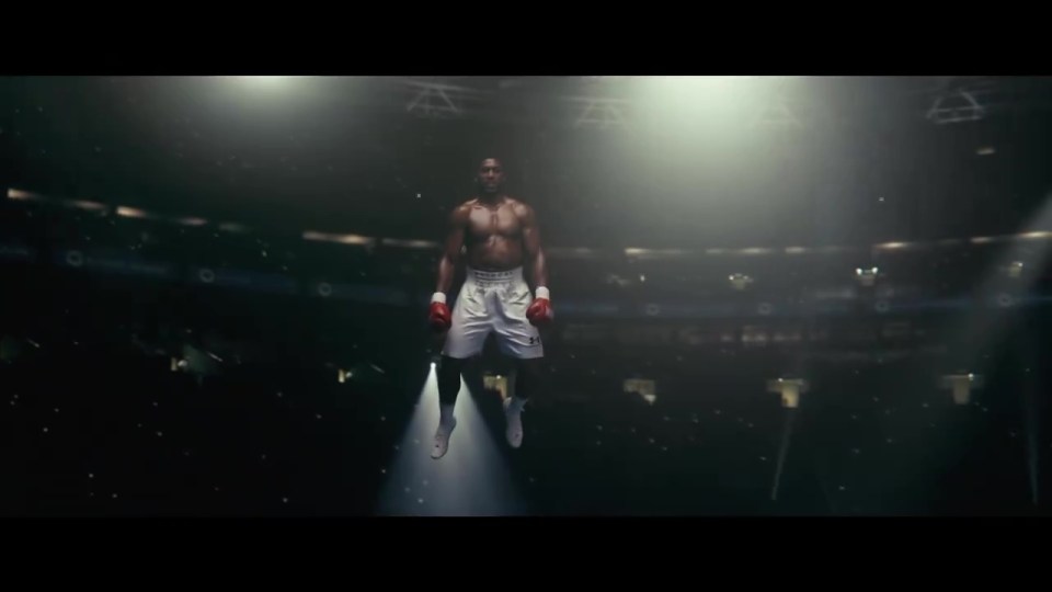 a man wearing boxing shorts and gloves is flying through the air