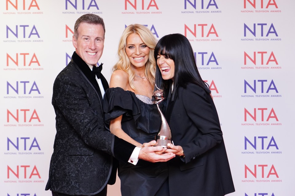 three people stand in front of a wall that says national television awards