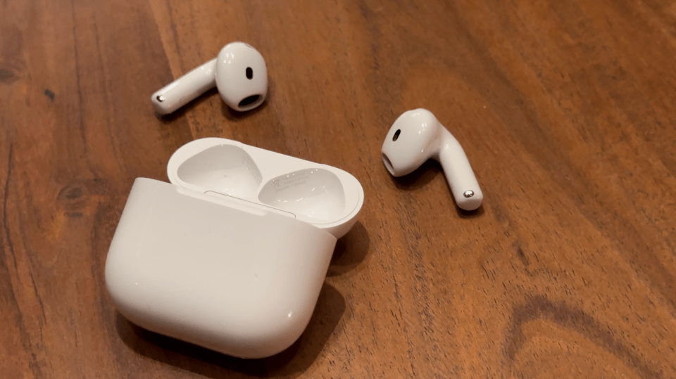 a pair of white earbuds are sitting on a wooden table