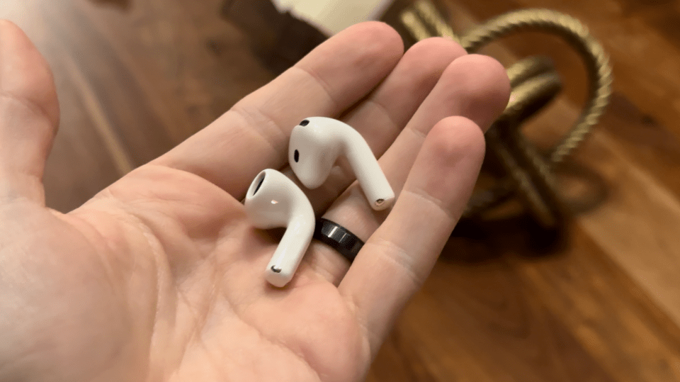 a person holding a pair of white earbuds in their hand