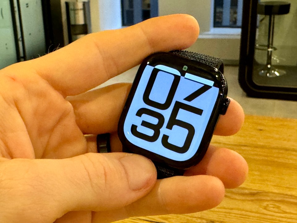 a person is holding a smart watch that shows the time as 07:30