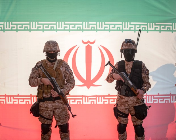 two soldiers are standing in front of a flag that has the letter w on it