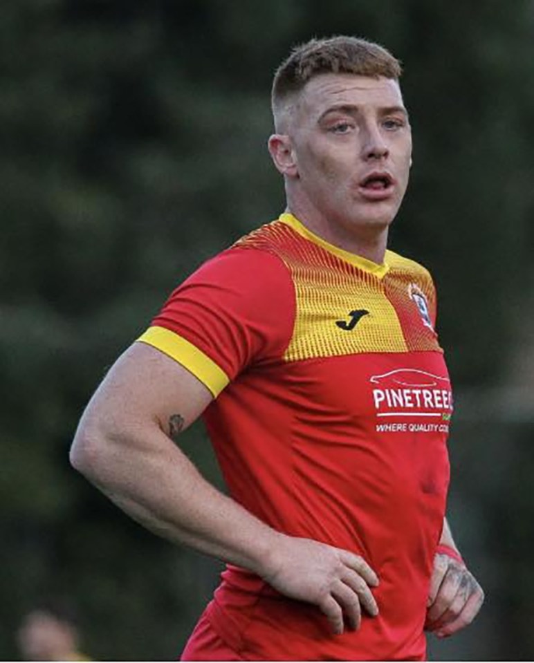 a man in a red and yellow soccer jersey is standing on a field .