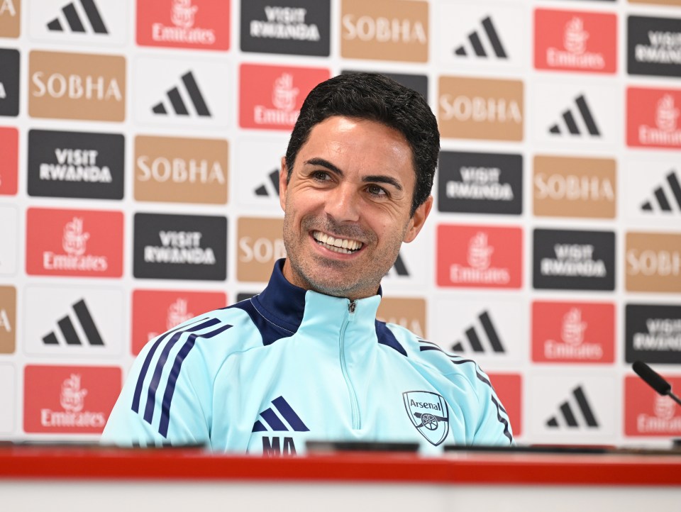 a man wearing a blue jacket with the word arsenal on it