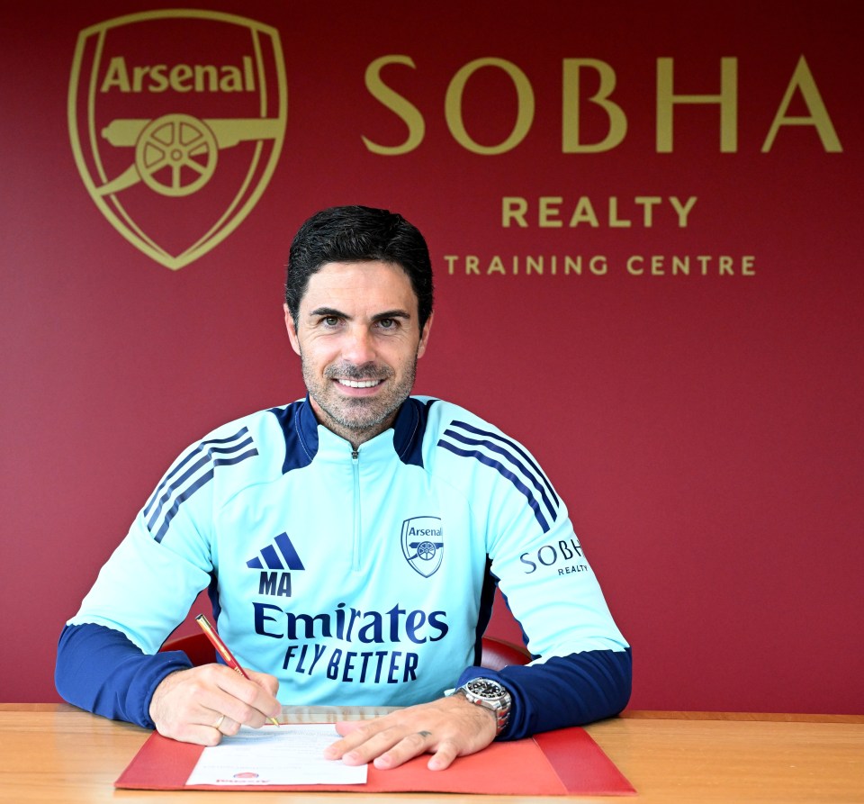 a man in an emirates fly better shirt sits at a desk